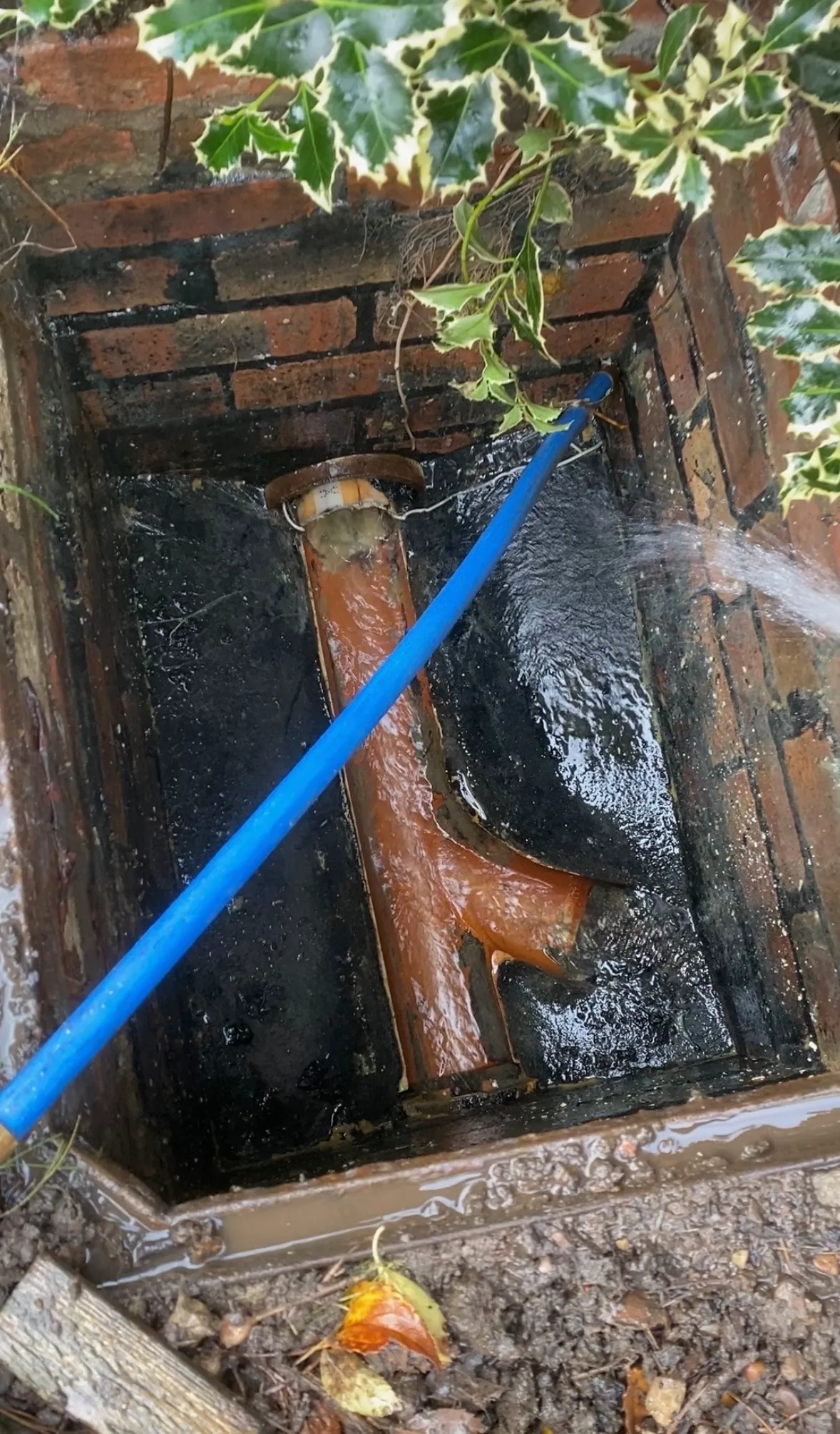 Blocked outside drain being cleared with drainage equipment