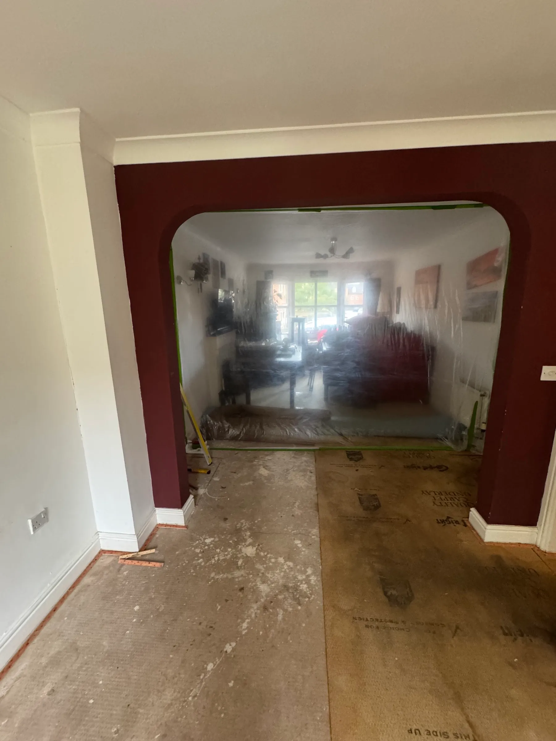 Living room sheeted and taped off around the working area before the floor came up