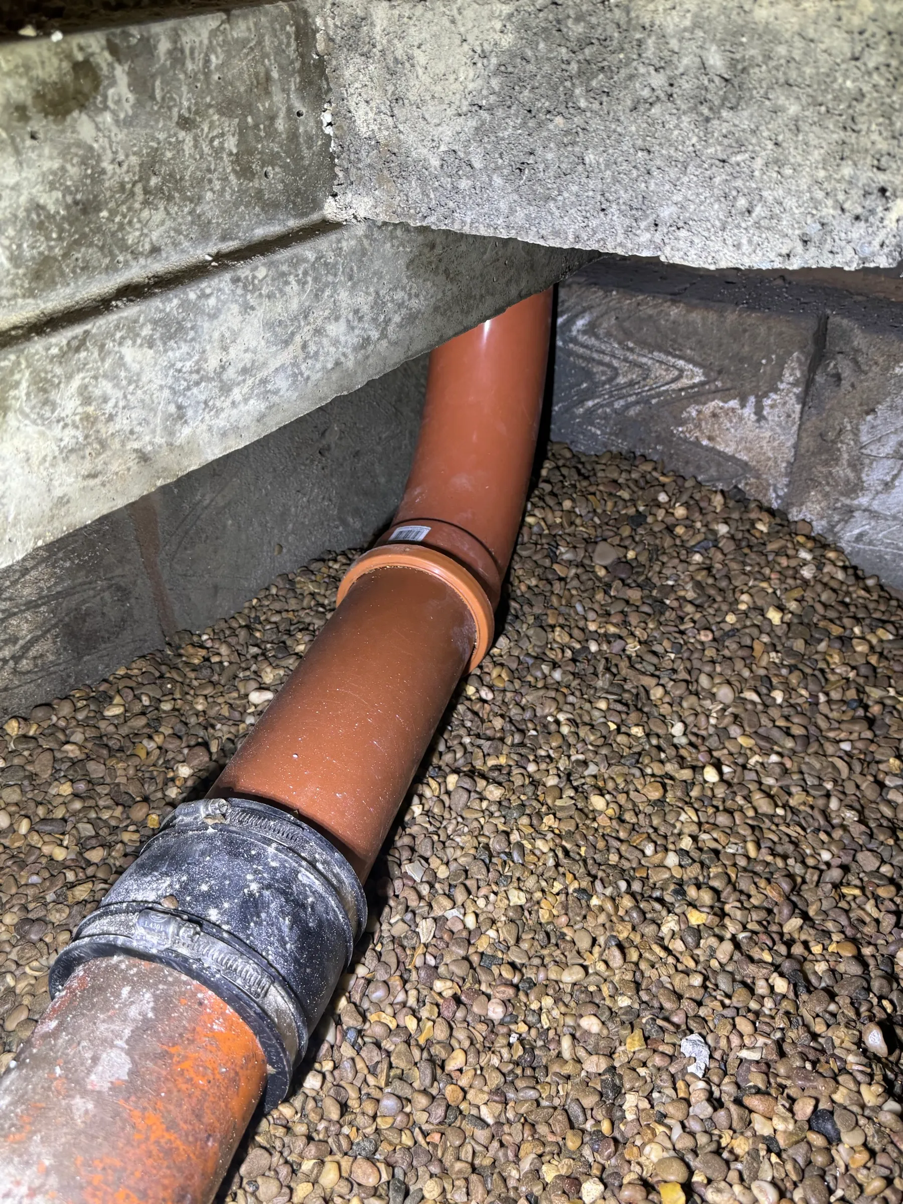 New drainage pipe laid and bedded on pea gravel to support the swept bend