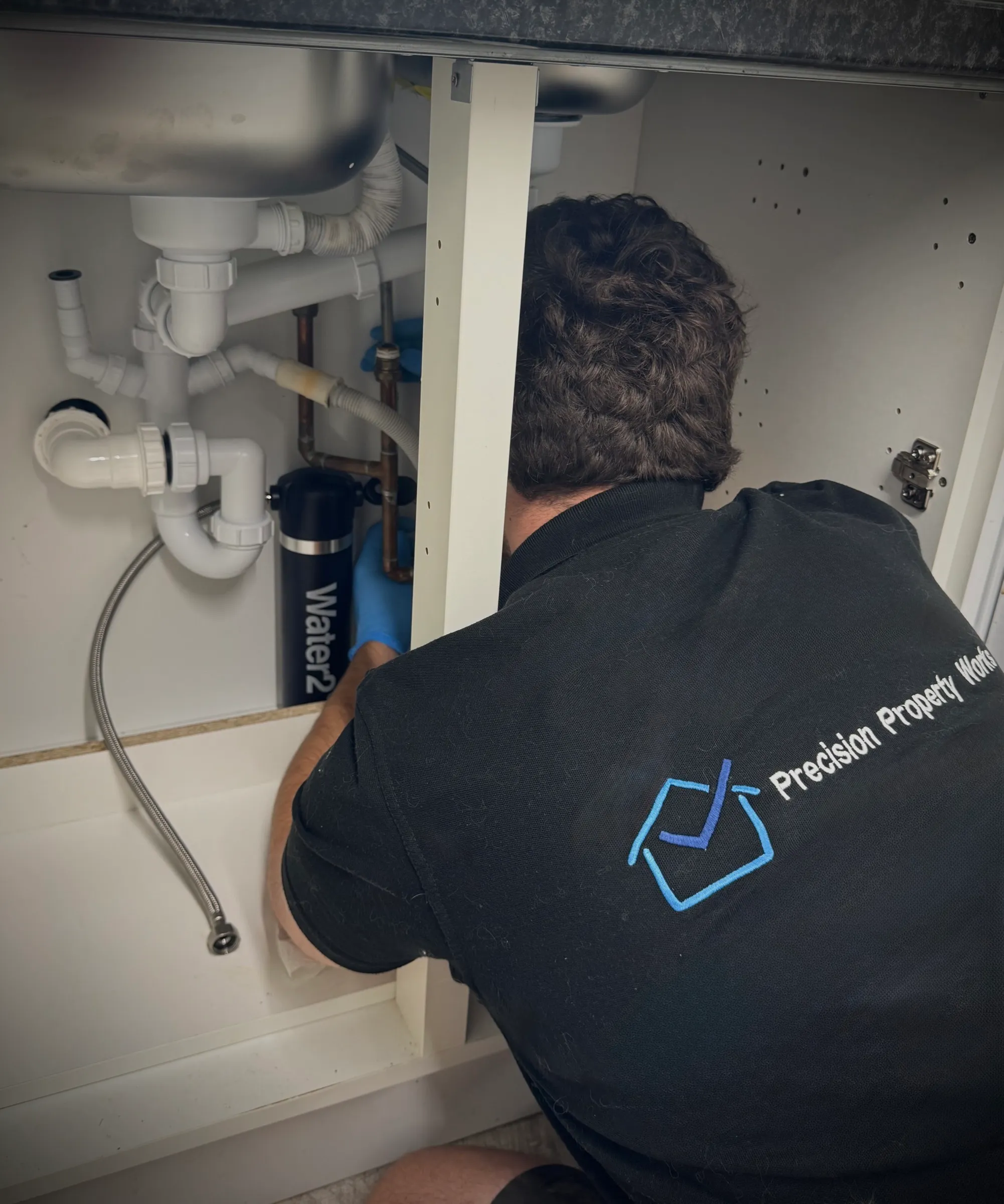 Water2 filter unit fitted under a kitchen sink alongside the existing waste pipework